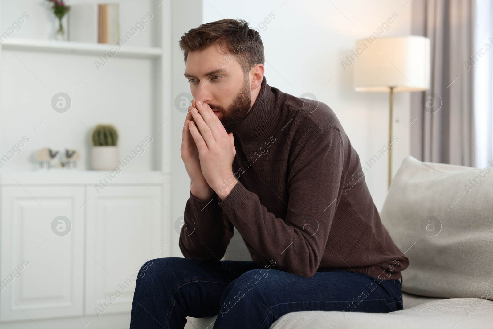 Photo of Loneliness concept. Sad man sitting on sofa at home