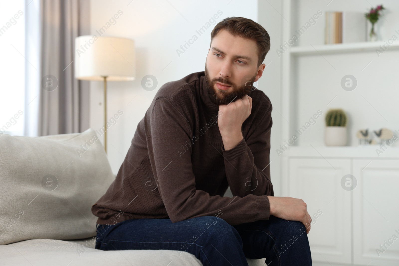 Photo of Loneliness concept. Sad man sitting on sofa at home