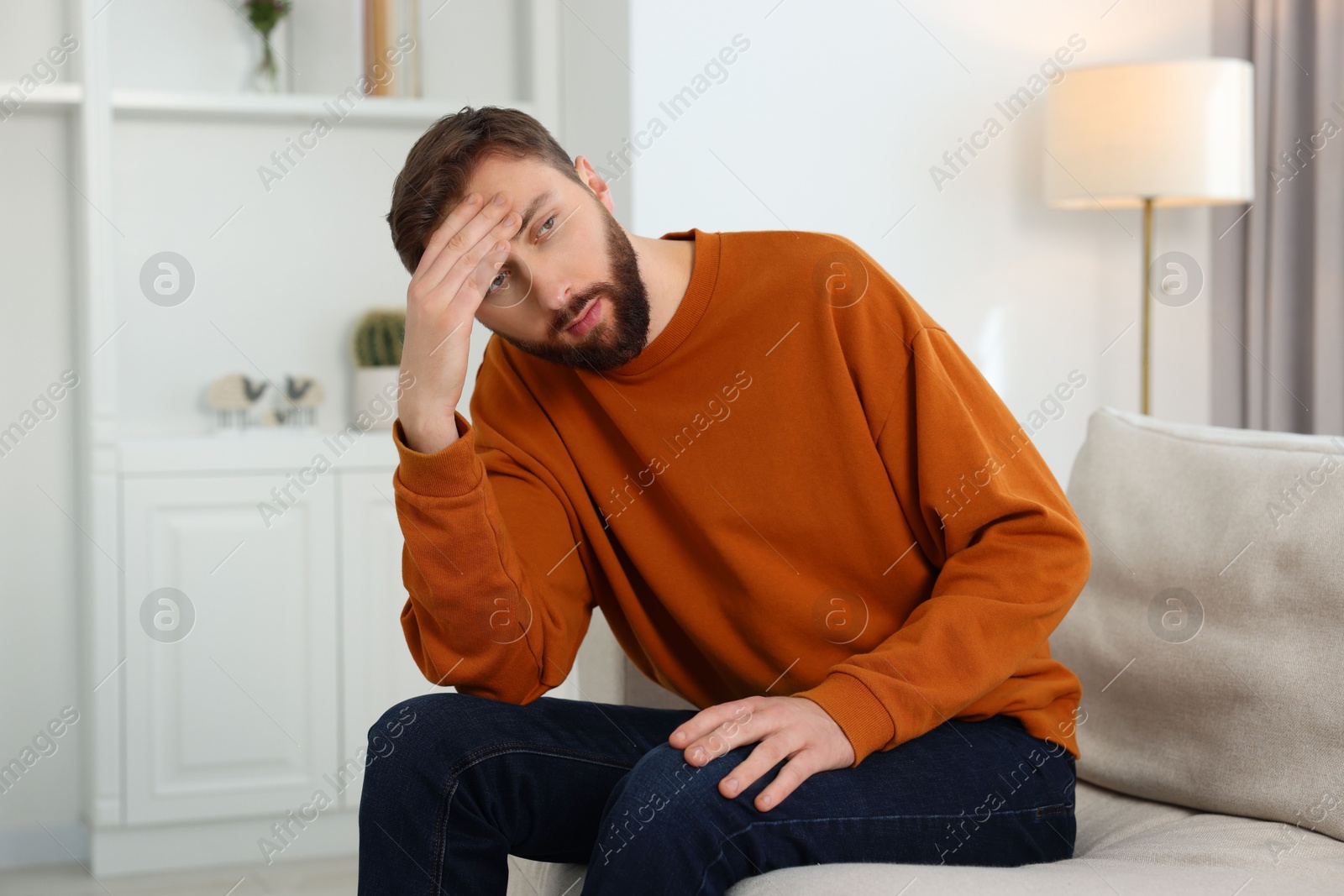 Photo of Loneliness concept. Sad man sitting on sofa at home