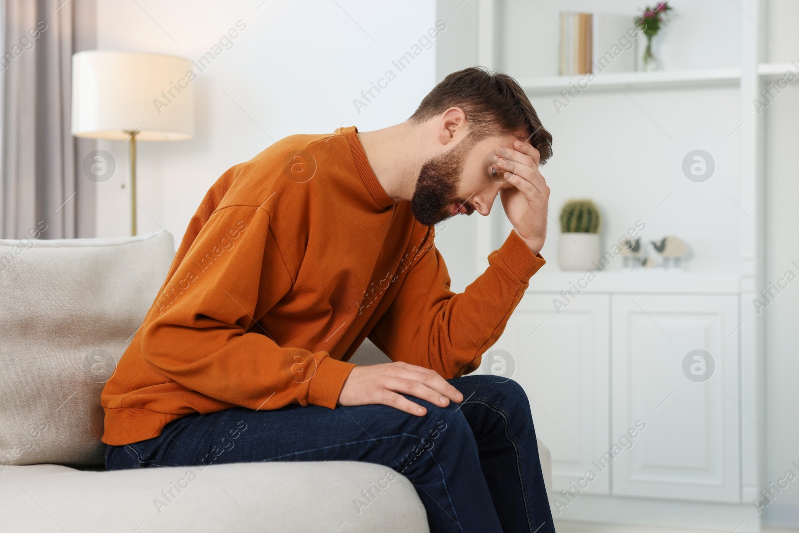 Photo of Loneliness concept. Sad man sitting on sofa at home