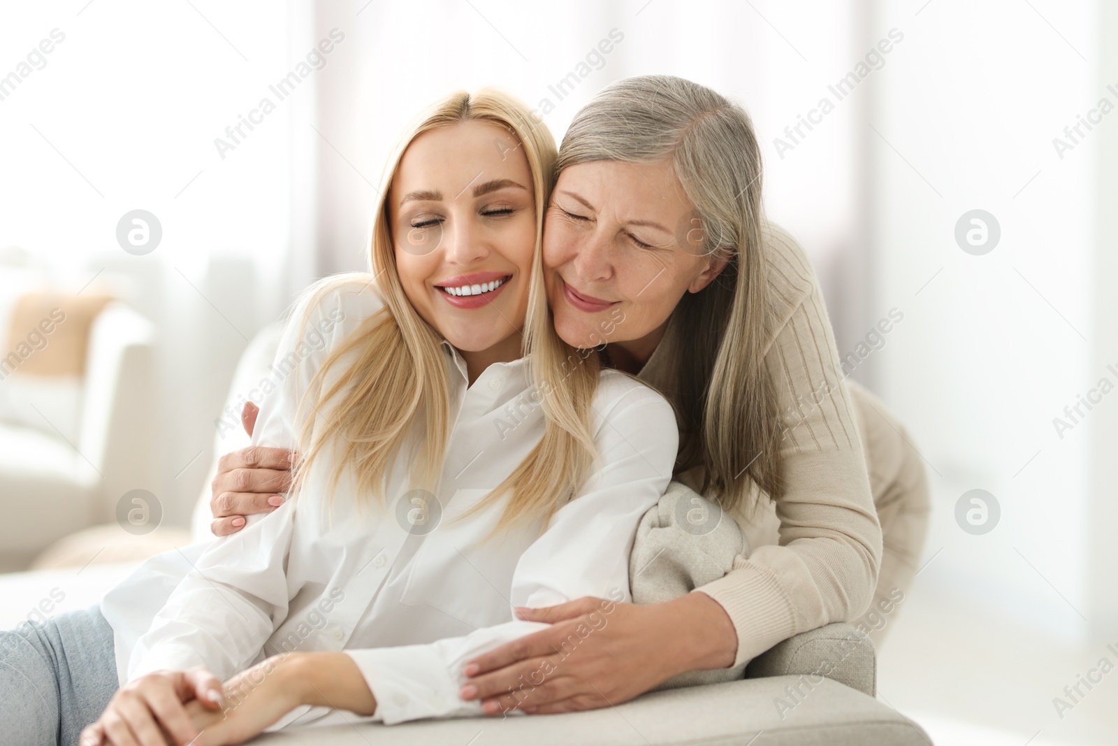 Photo of Family portrait of young woman and her mother at home