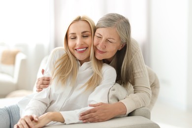 Family portrait of young woman and her mother at home