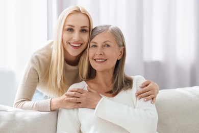 Family portrait of young woman and her mother at home