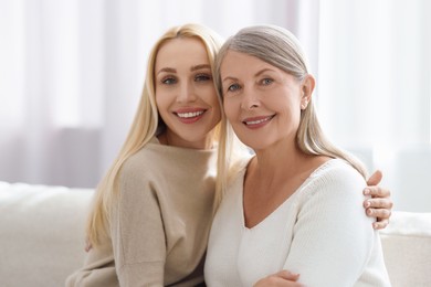 Family portrait of young woman and her mother at home