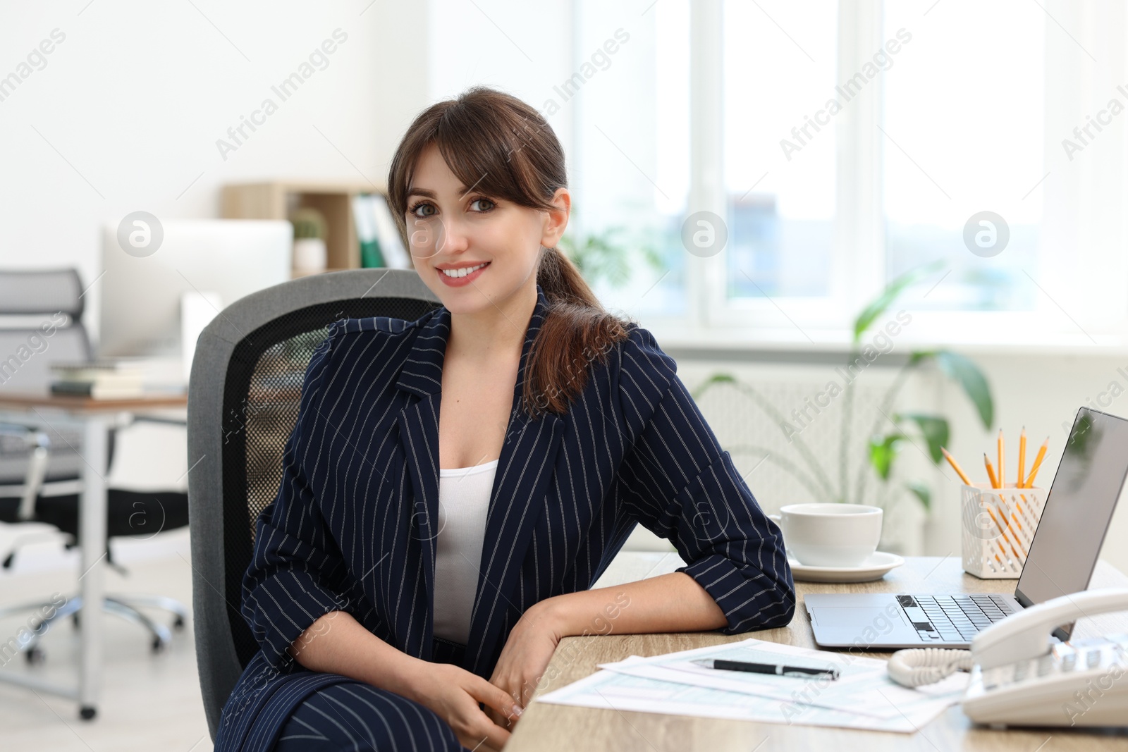 Photo of Portrait of smiling secretary at table in office