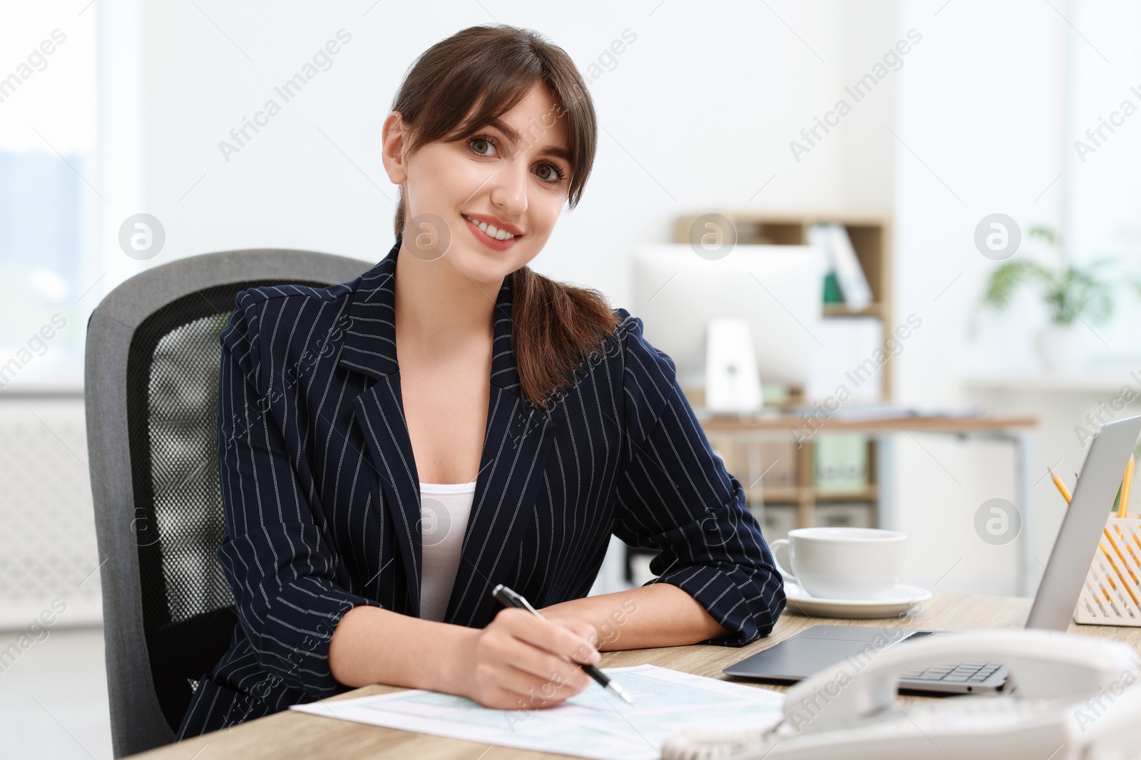 Photo of Portrait of smiling secretary at table in office