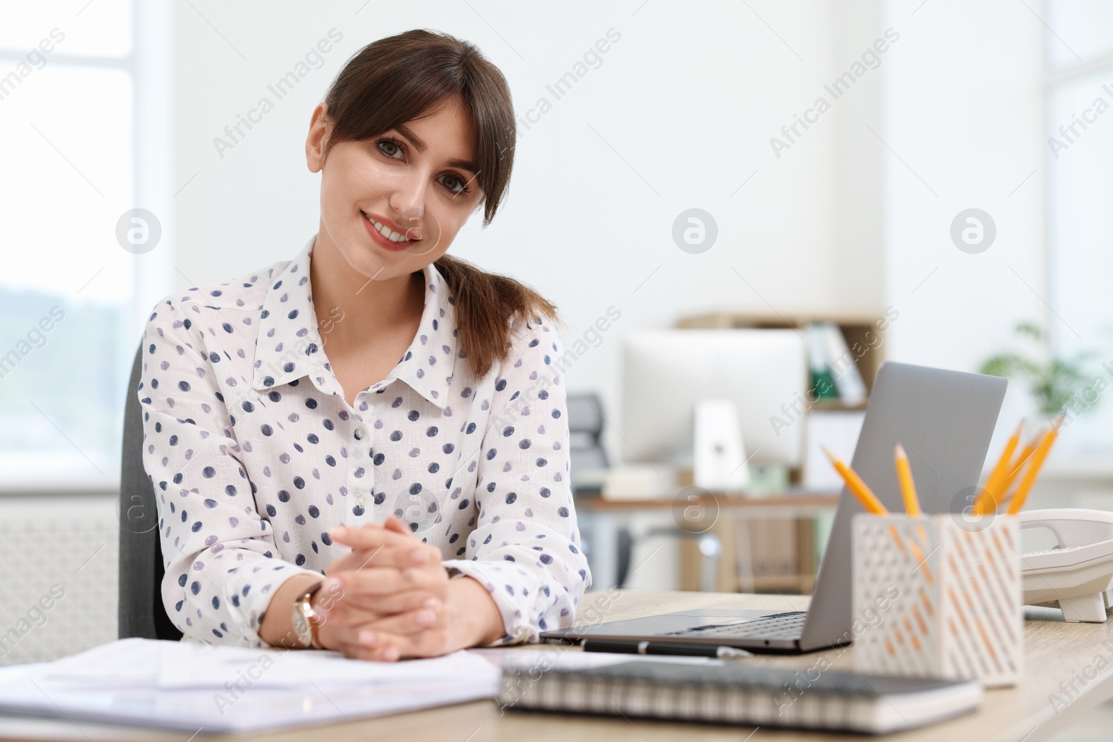 Photo of Portrait of smiling secretary at table in office