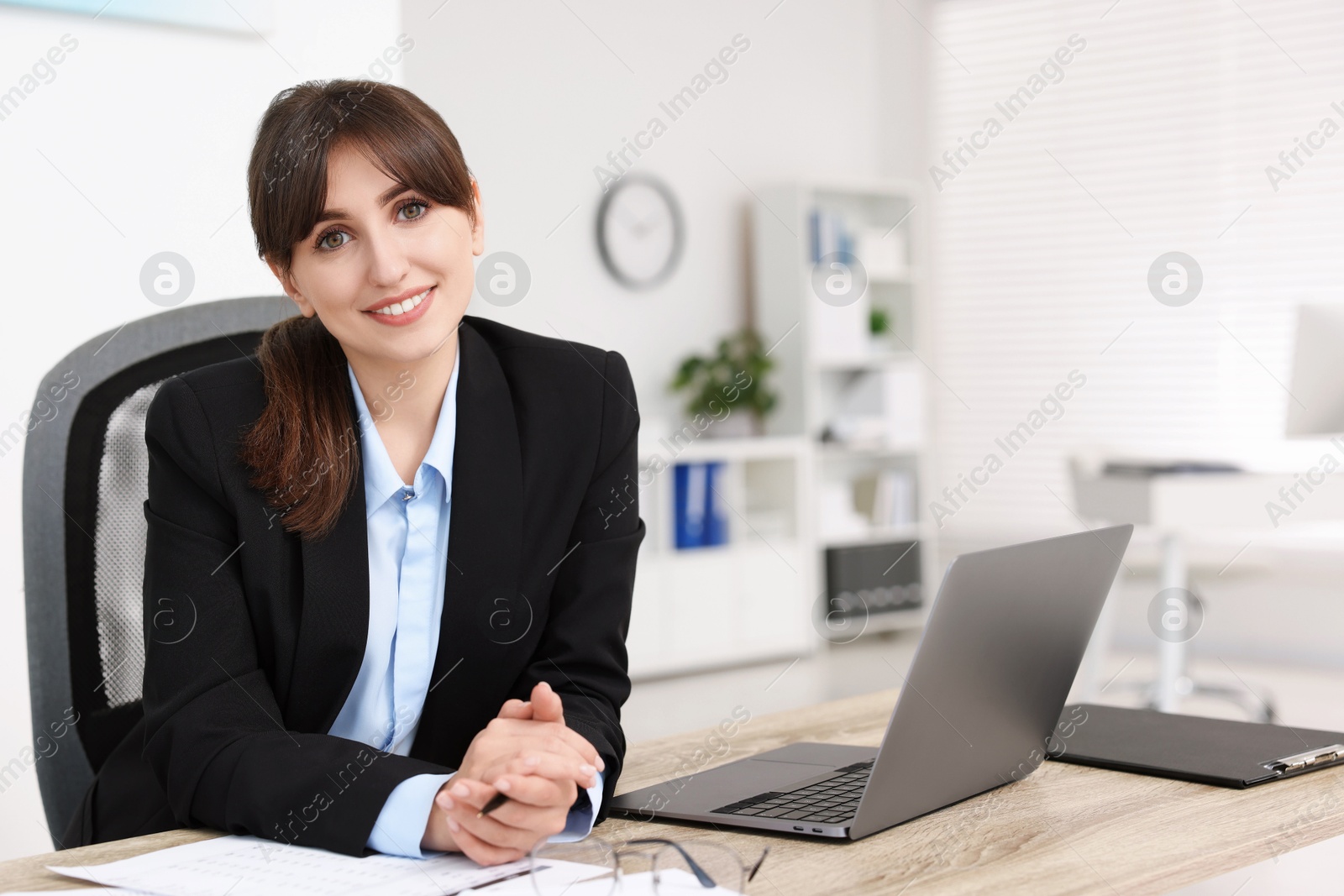 Photo of Portrait of smiling secretary at table in office