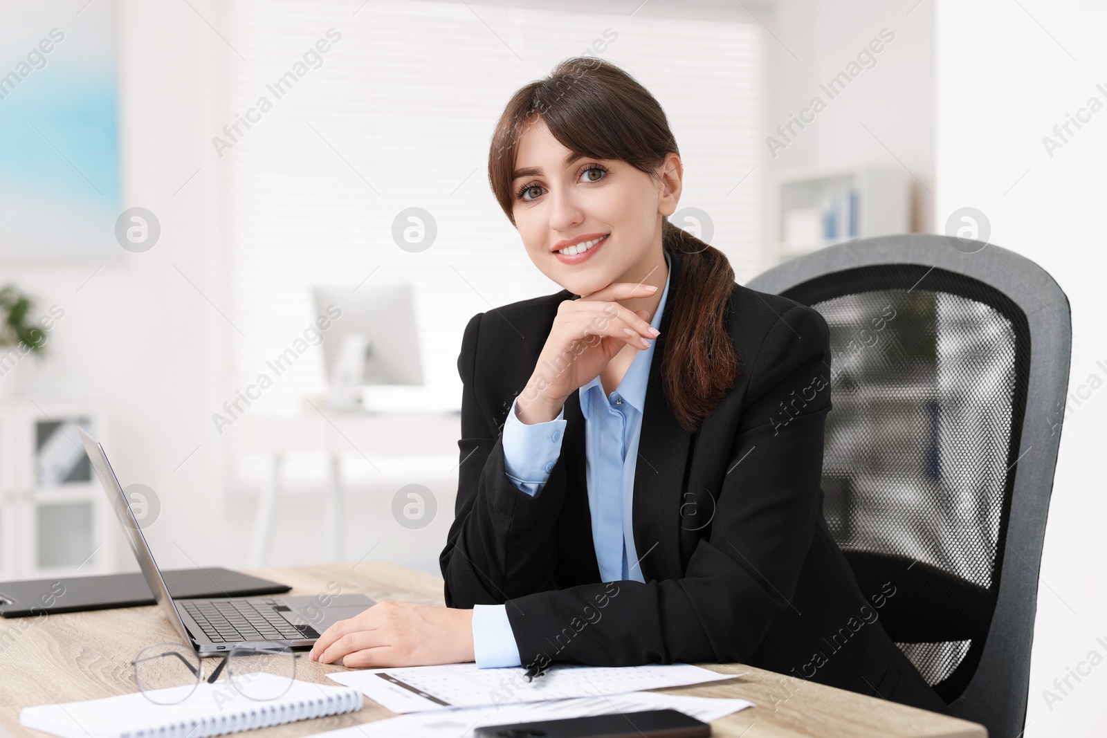 Photo of Portrait of smiling secretary at table in office