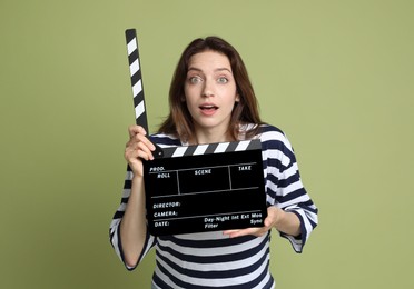Photo of Making movie. Woman with clapperboard on green background