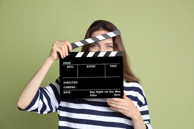 Photo of Making movie. Woman with clapperboard on green background