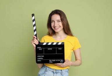 Photo of Making movie. Smiling woman with clapperboard on green background