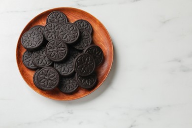 Photo of Plate with tasty sandwich cookies on white marble table, top view. Space for text