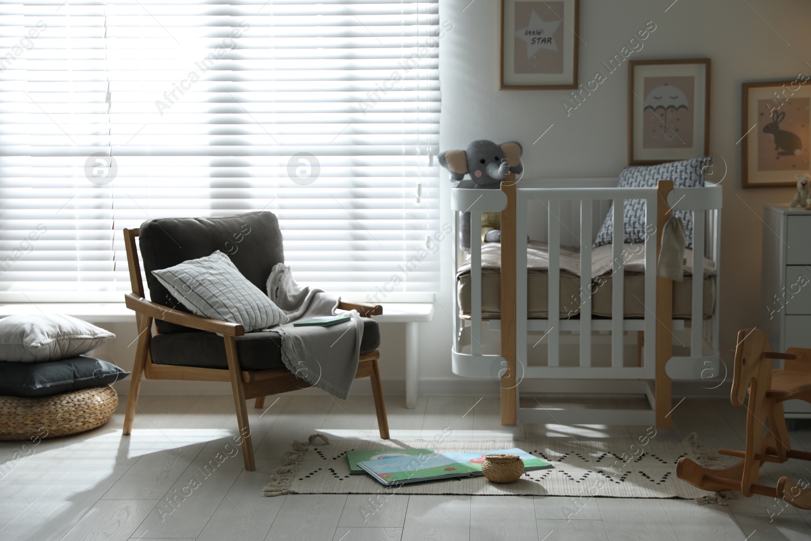 Photo of Baby room interior with crib and armchair. Idea for design