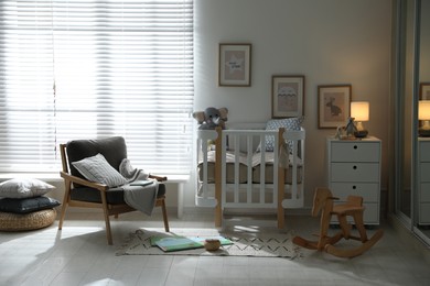 Photo of Baby room interior with crib, armchair and rocking horse. Idea for design