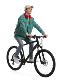 Smiling man with headphones riding bicycle on white background