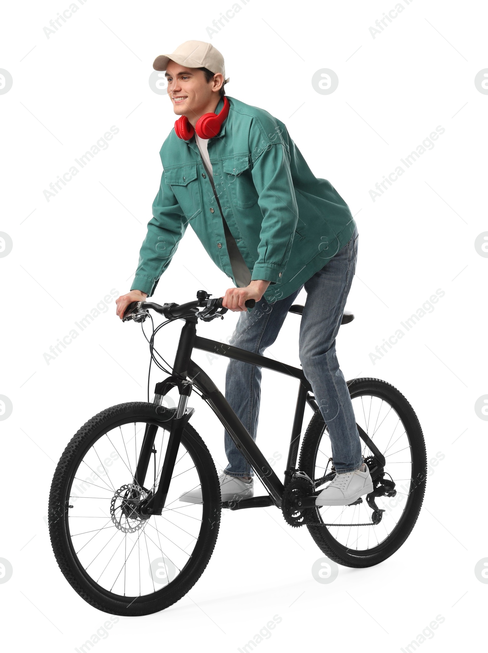 Photo of Smiling man with headphones riding bicycle on white background