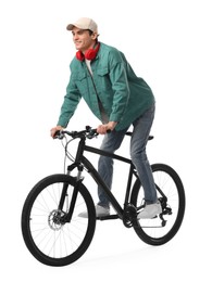 Photo of Smiling man with headphones riding bicycle on white background