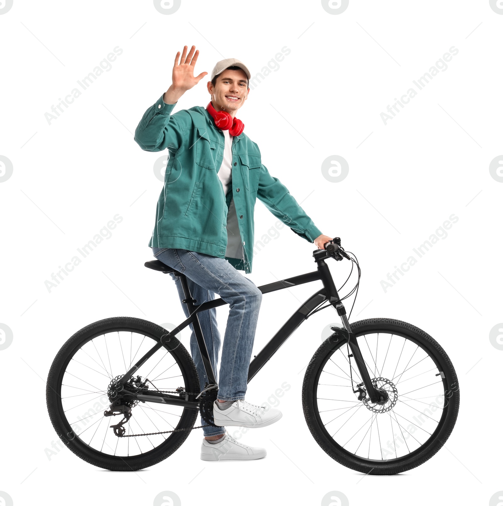 Photo of Smiling man with headphones riding bicycle on white background