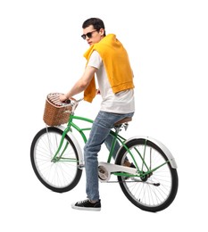 Man in sunglasses riding bicycle with basket on white background