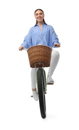 Smiling woman riding bicycle with basket on white background