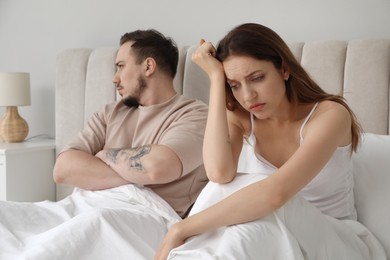 Photo of Offended couple after quarrel ignoring each other in bedroom. Relationship problem