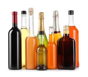 Photo of Bottles of different alcoholic drinks isolated on white