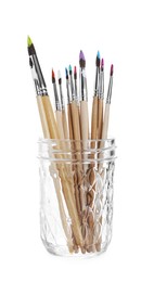 Photo of Wooden brushes with colorful paints in glass isolated on white