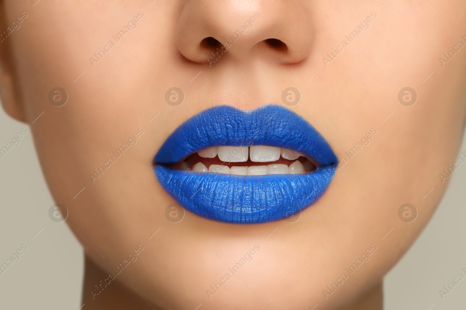 Photo of Woman wearing blue lipstick on light background, closeup view