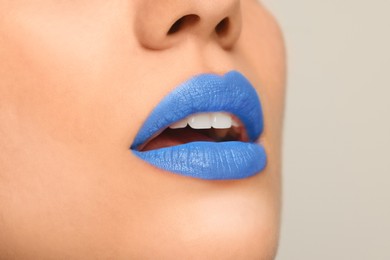 Woman wearing blue lipstick on light background, closeup. Space for text