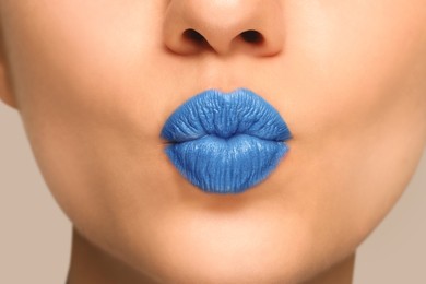 Woman with light blue lipstick sending air kiss, closeup view
