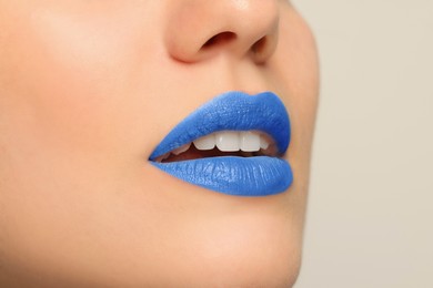 Photo of Woman wearing blue lipstick on light background, closeup. Space for text