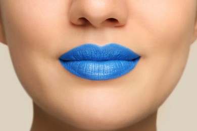 Woman wearing blue lipstick on light background, closeup view