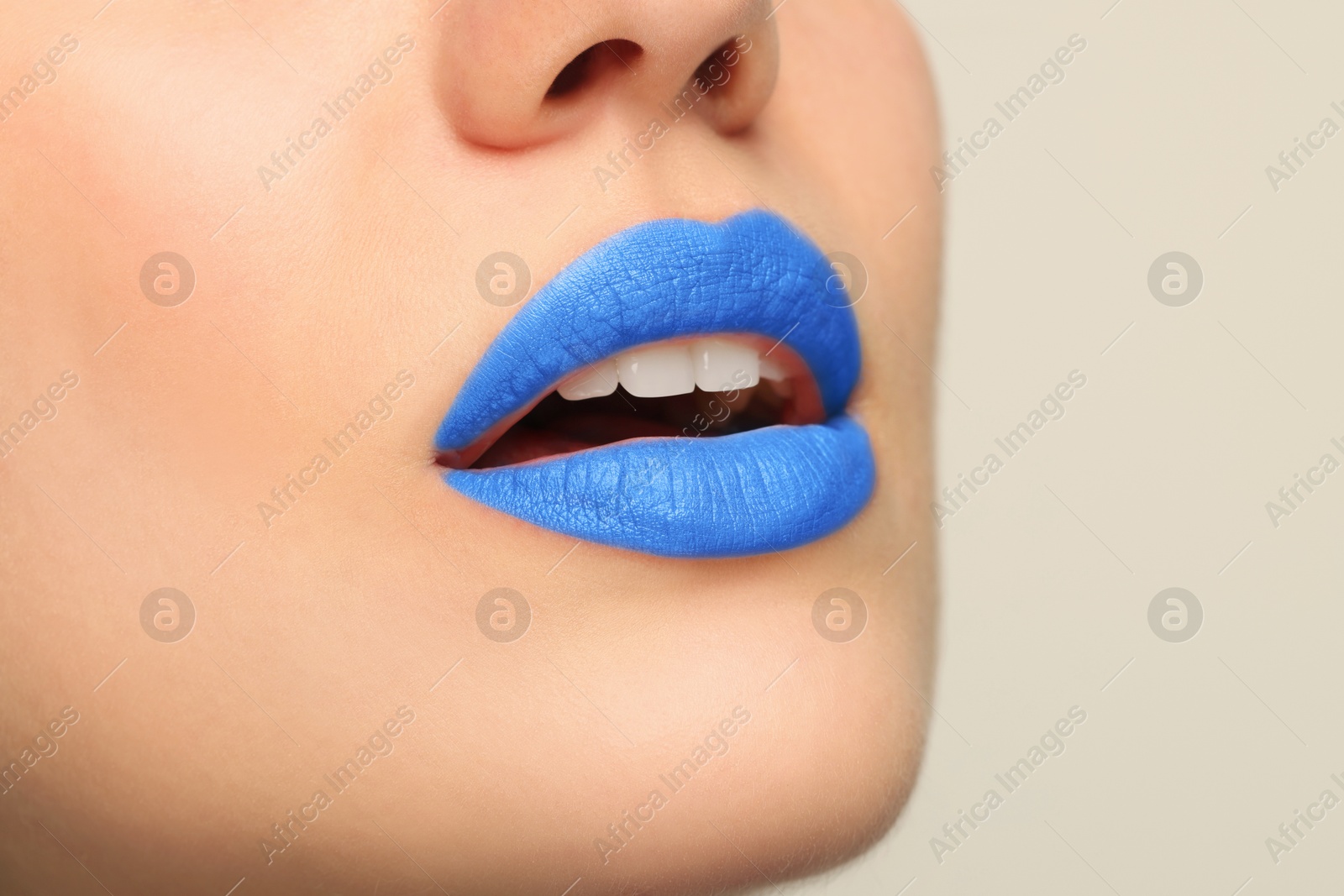 Photo of Woman wearing blue lipstick on light background, closeup. Space for text