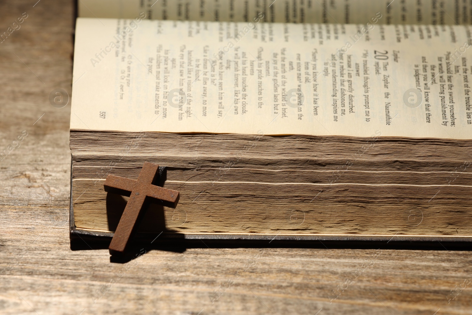 Photo of Bible and cross on wooden table, closeup. Religion of Christianity