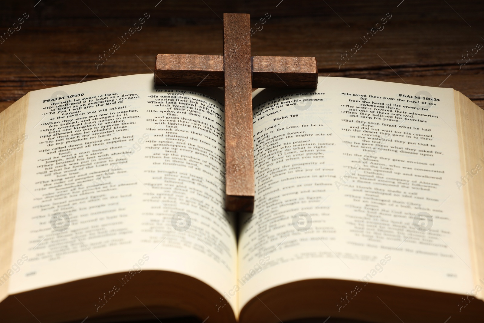 Photo of Bible and cross on table, closeup. Religion of Christianity