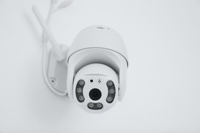 Photo of White CCTV camera on wall, closeup. Home security system