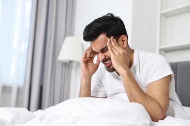 Photo of Morning of man suffering from headache in bed