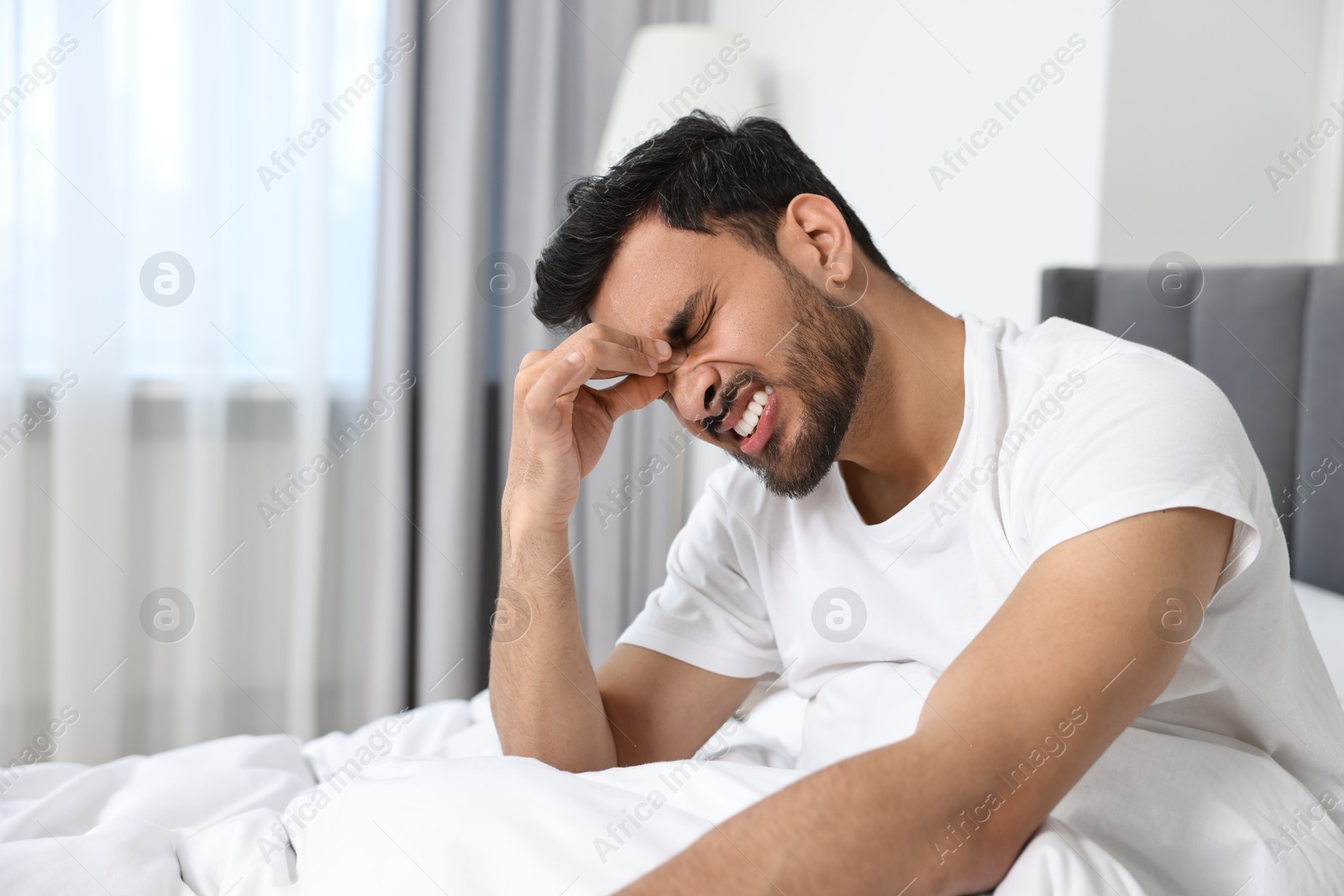 Photo of Morning of man suffering from headache in bed