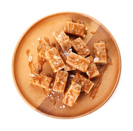 Photo of Plate with tasty candies, caramel sauce and salt isolated on white, top view