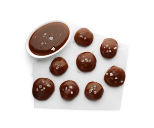 Photo of Tasty candies, caramel sauce and salt isolated on white, top view