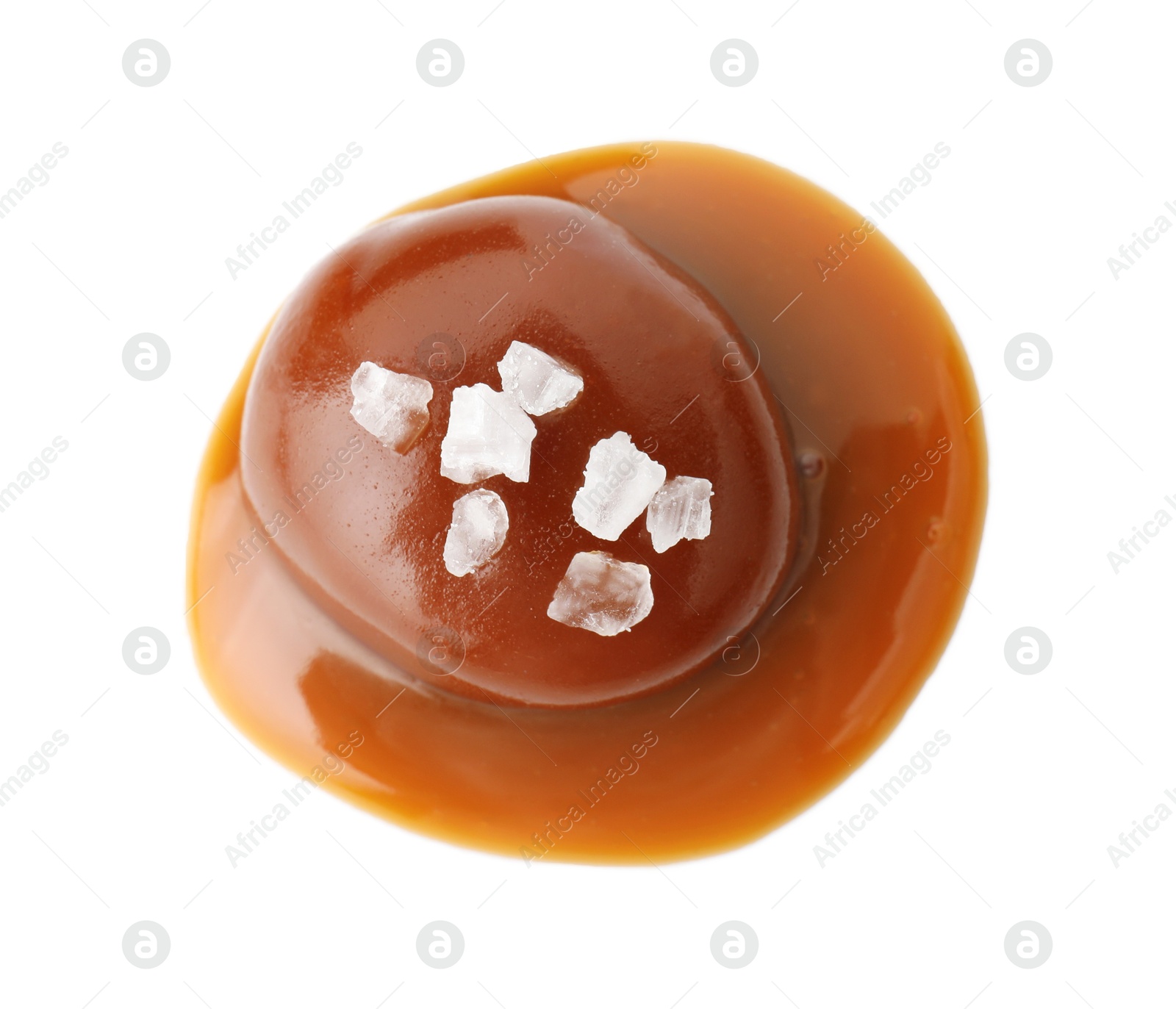 Photo of Tasty candy, caramel sauce and salt isolated on white, top view