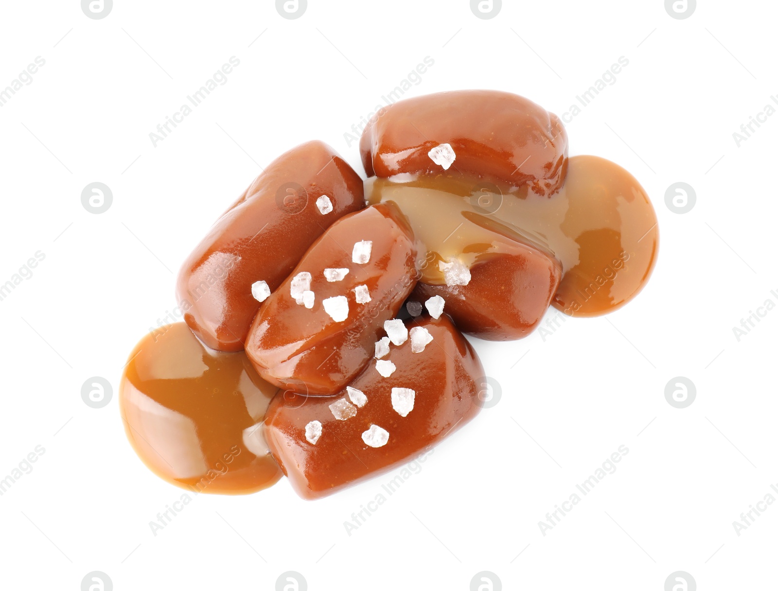Photo of Tasty candies, caramel sauce and salt isolated on white, top view