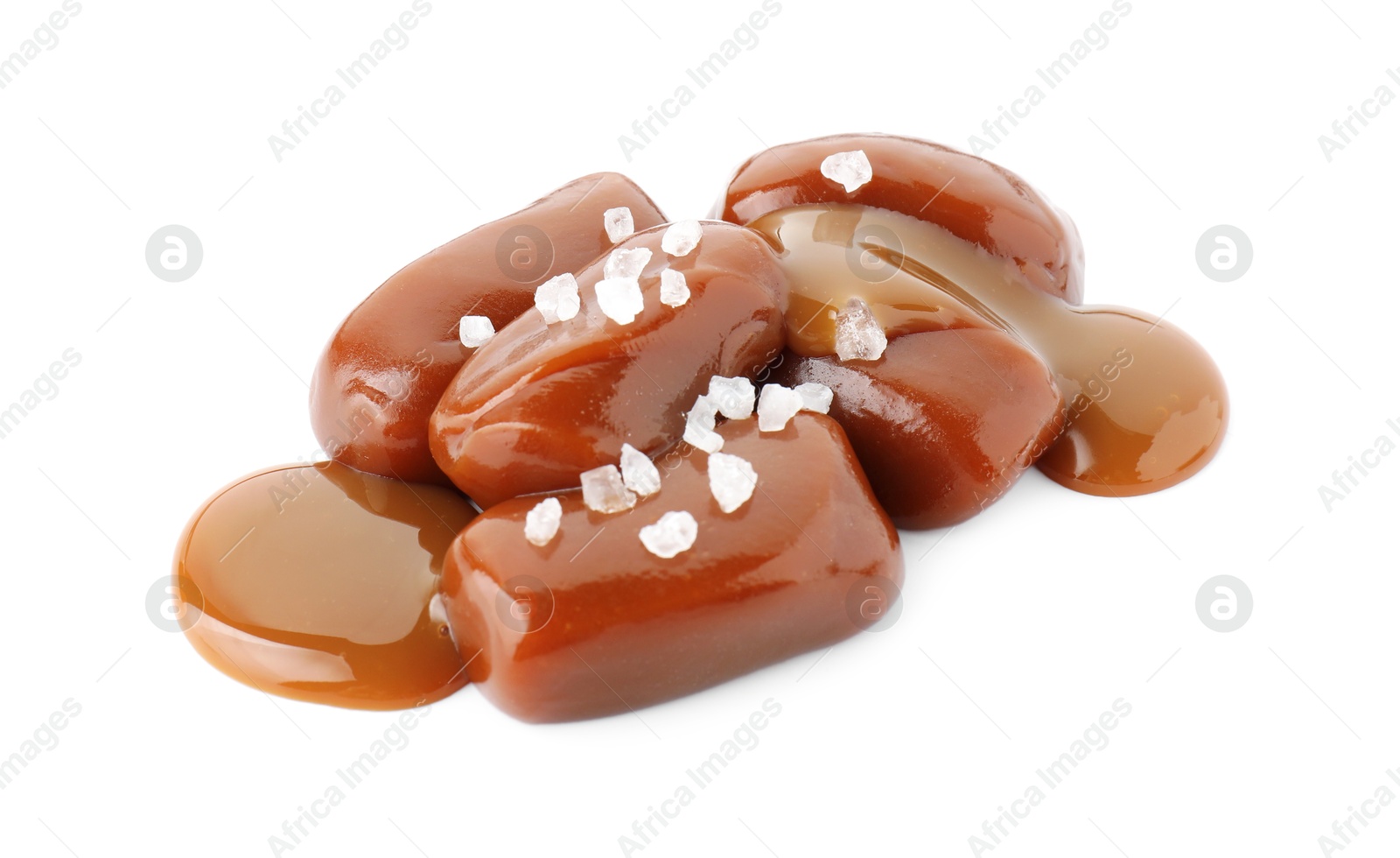 Photo of Tasty candies, caramel sauce and salt isolated on white