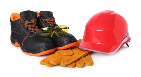 Photo of Pair of working boots, hard hat, gloves and protective goggles isolated on white