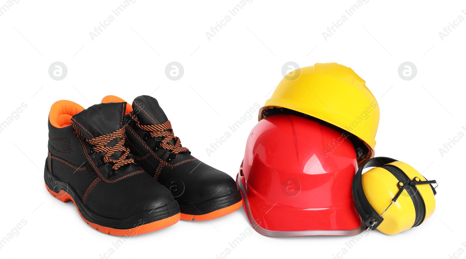Photo of Pair of working boots, hard hats and earmuffs isolated on white