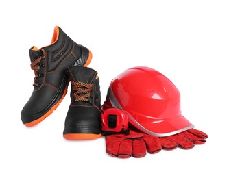 Photo of Pair of working boots, hard hat, tape measure and protective gloves isolated on white