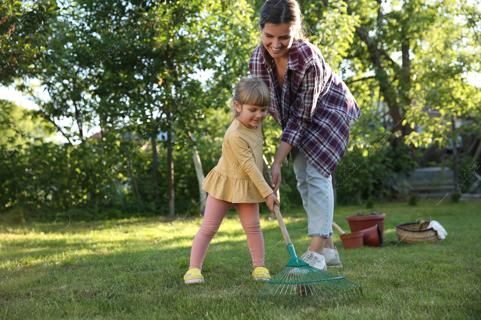 Photo of Mother and her daughter working together in garden