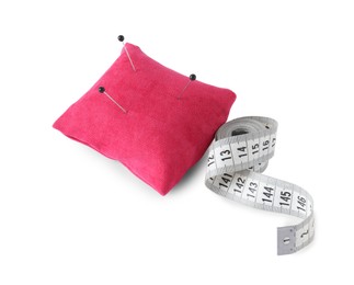 Photo of Pink pincushion with sewing pins and measuring tape isolated on white