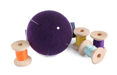 Photo of Pincushion, sewing needles, pins and spools with threads isolated on white